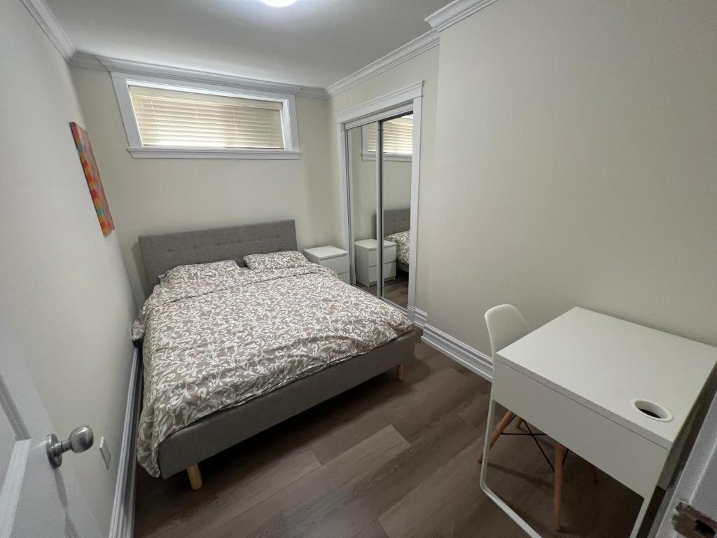 1 dormitorio con cama, mesa y ventana en Private suite 1 bed 1 bath 15 mins YVR and downtown 舒适安静, en Vancouver