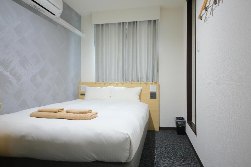 Postel nebo postele na pokoji v ubytování Hotel Shin-Imamiya