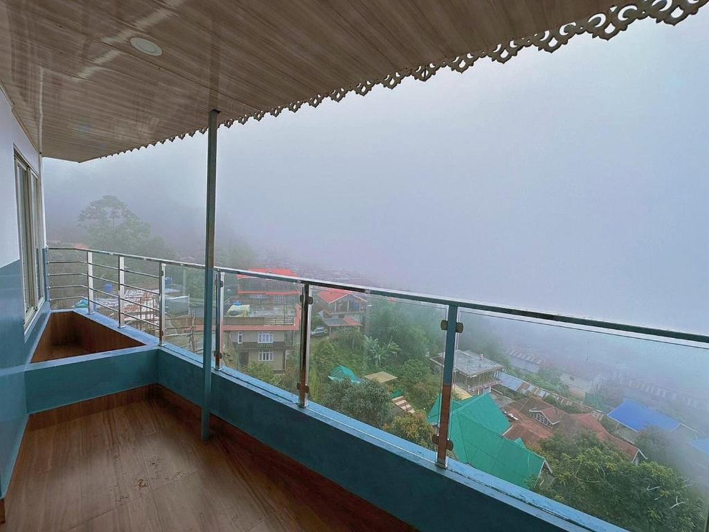 a room with a balcony with a view of a city at HOTEL ARMS near SUMI Boys School in Kalimpong