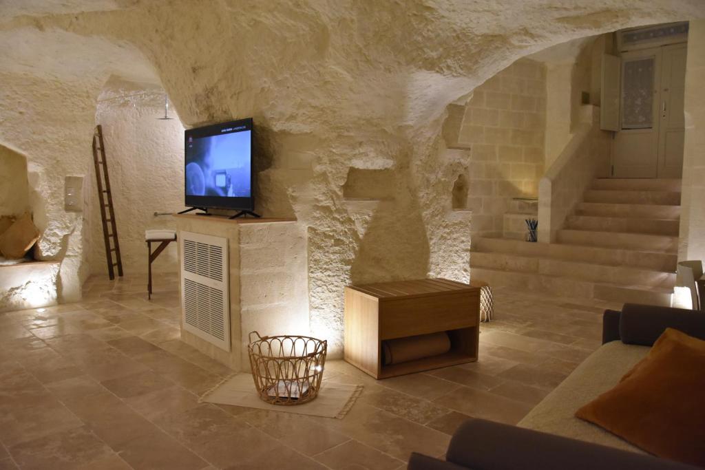 a living room with a tv on a stone wall at Il Belvedere in Matera
