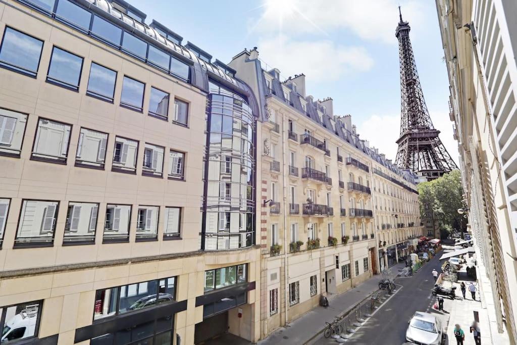 Une rue avec des bâtiments et la tour Eiffel dans l'établissement Séjour au pied de la tour Eiffel, à Paris