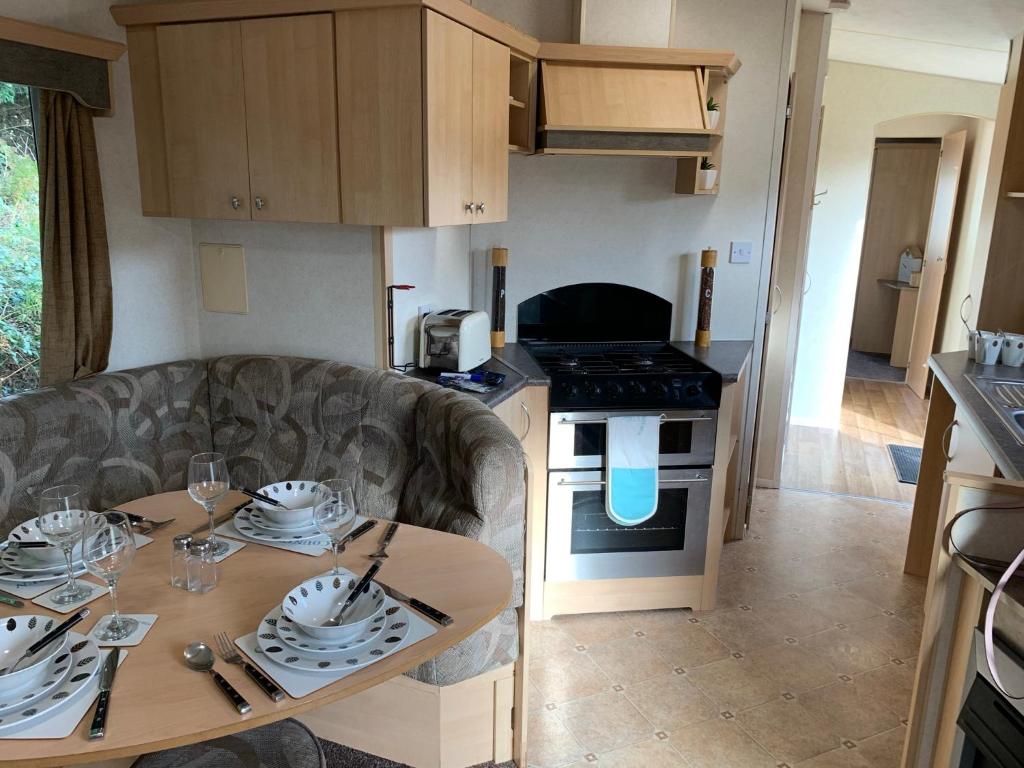 eine kleine Küche mit einem Tisch und einem Esszimmer in der Unterkunft Kingsgate 49 in Shanklin