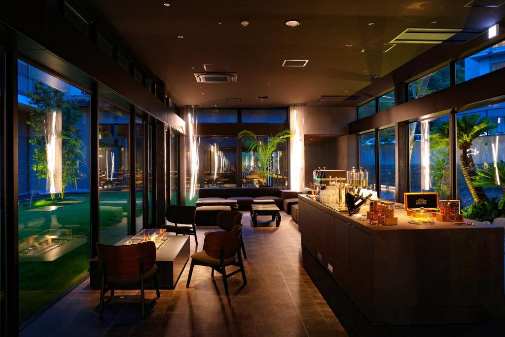 a restaurant with a bar and tables and windows at TAOYA Nasu Shiobara in Nasushiobara
