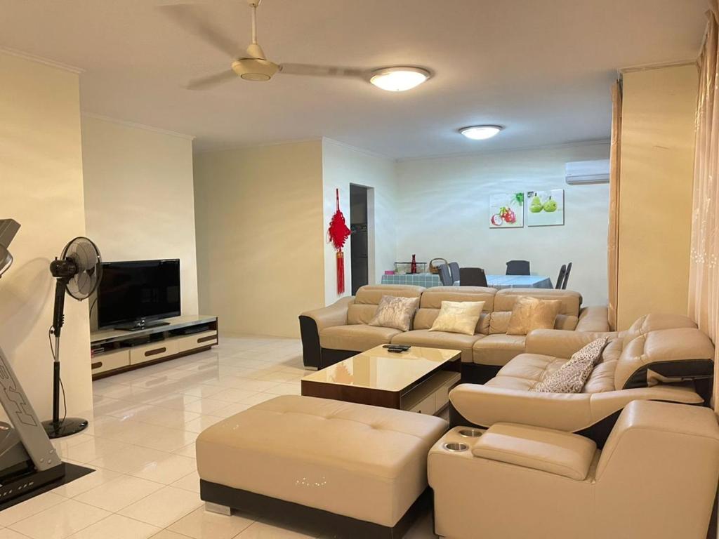 Il comprend un salon avec des canapés et une télévision à écran plat. dans l'établissement 4BR 9pax in Kuching city, à Kuching