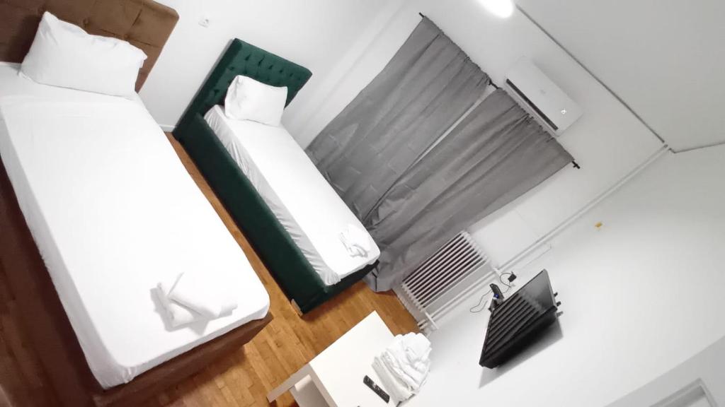 een kleine slaapkamer met 2 bedden en een radiator bij Appartement tout confort in Athene
