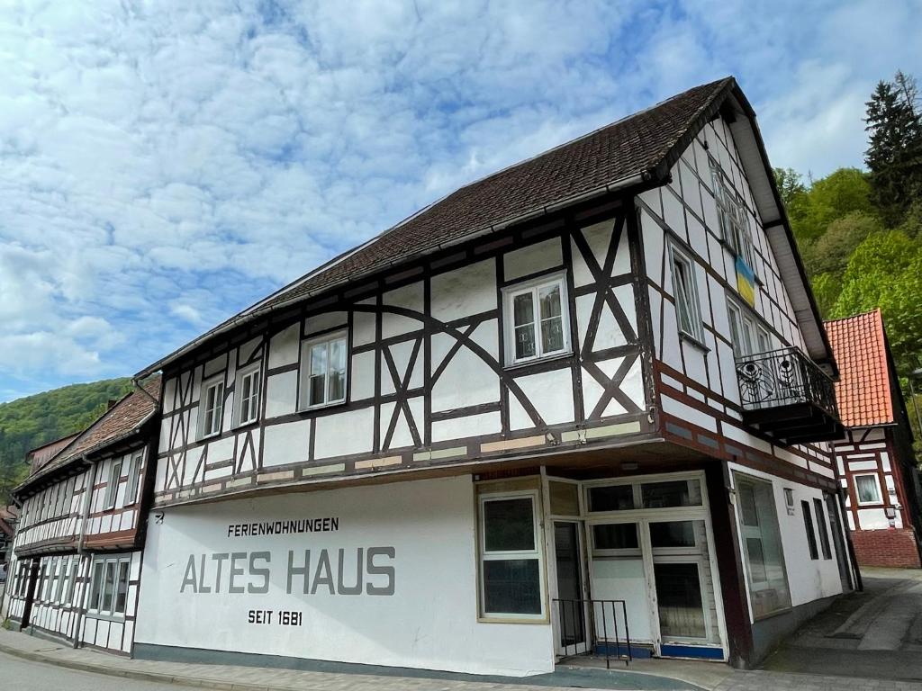 un antiguo edificio con blanco y negro en "Altes Haus" am Kurpark in den Bergen, en Zorge