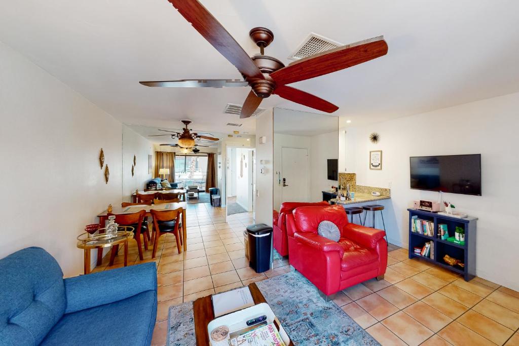 a living room with a couch and a ceiling fan at Kitschy Rich Palm Springs Permit #60096 in Palm Springs