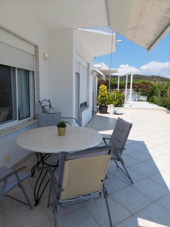 a white table and chairs on a patio at Seaview dreams in Ormos Panagias
