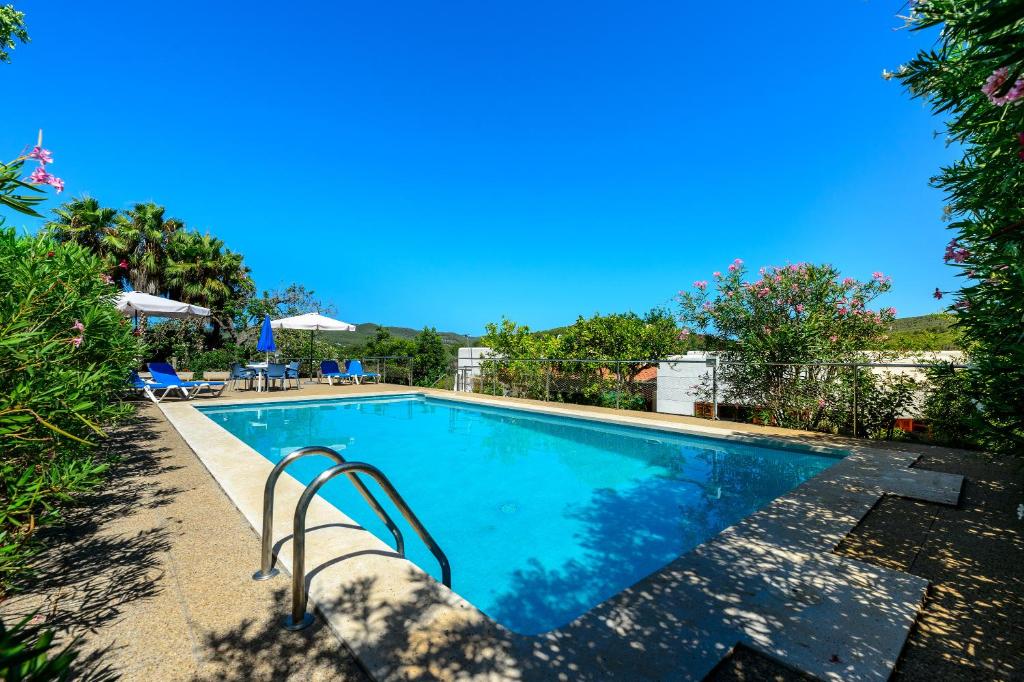 a swimming pool at a resort with blue skies at Villa Can Joan den Coves in Santa Gertrudis de Fruitera