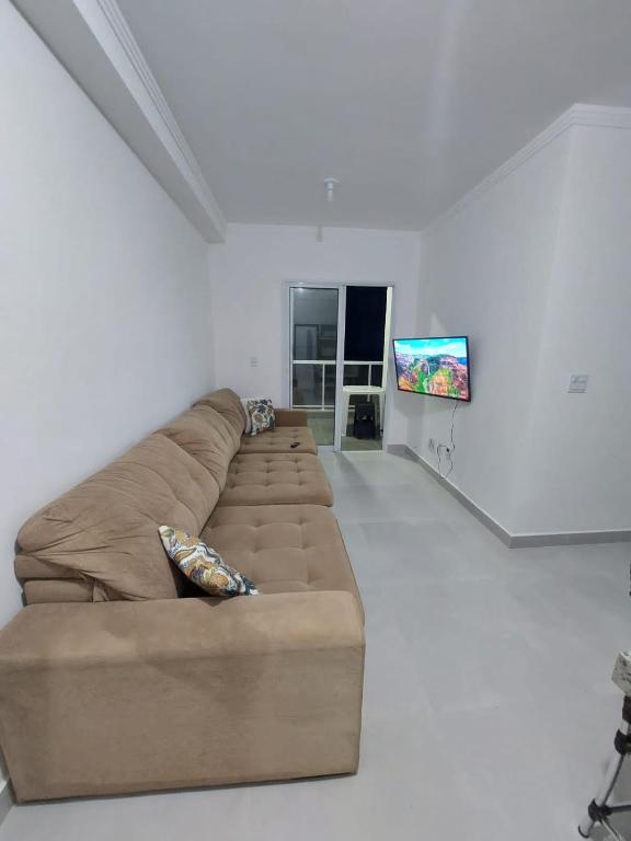 Uma TV ou centro de entretenimento em Apartamento Recanto Praia Grande - Mar, Ar, Churrasqueira, Piscina e Sauna