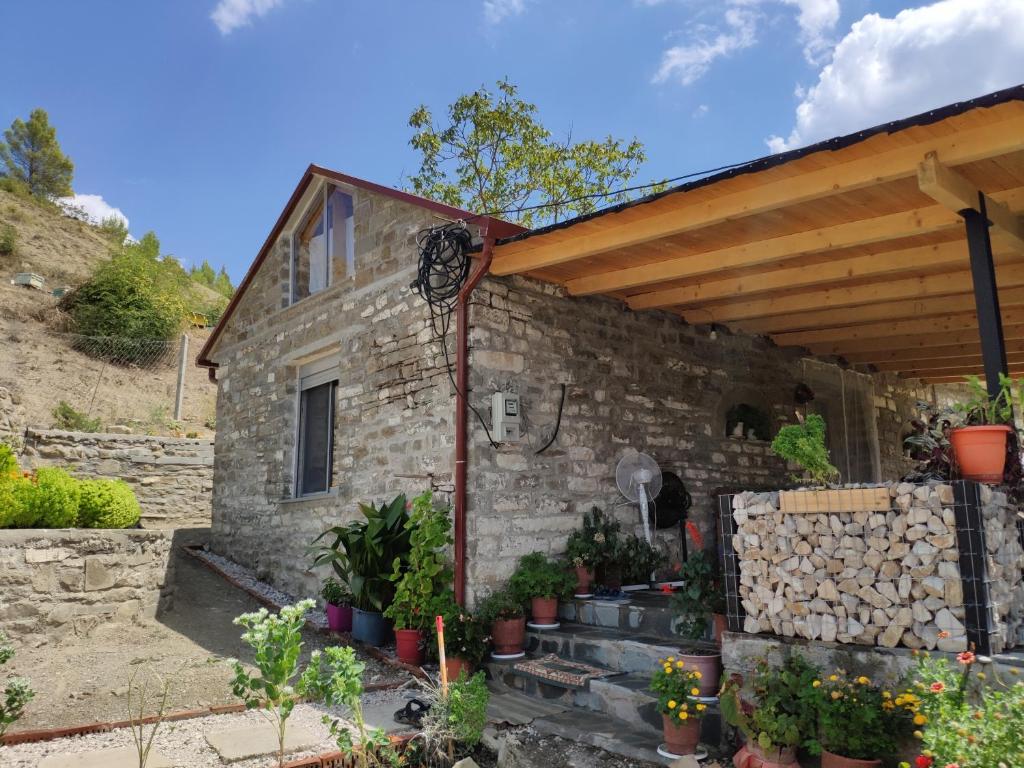 a stone house with a wooden roof at Stone House in Këlcyrë