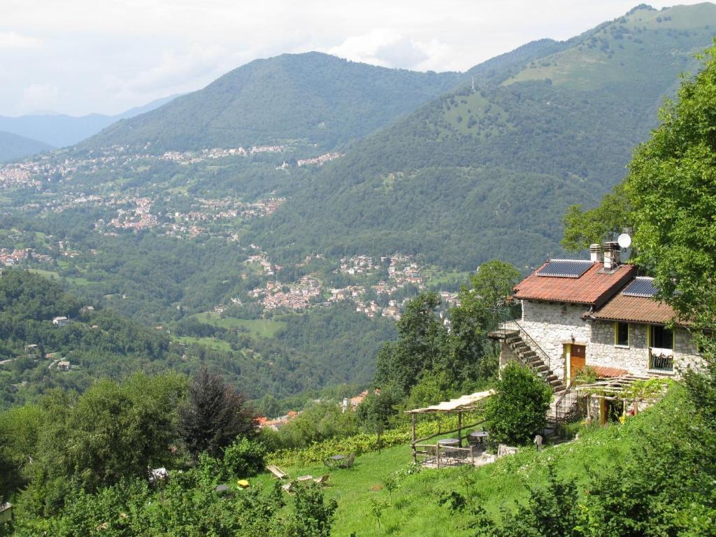 a house on a hill with mountains in the background at Agriturismo Al Marnich in Schignano