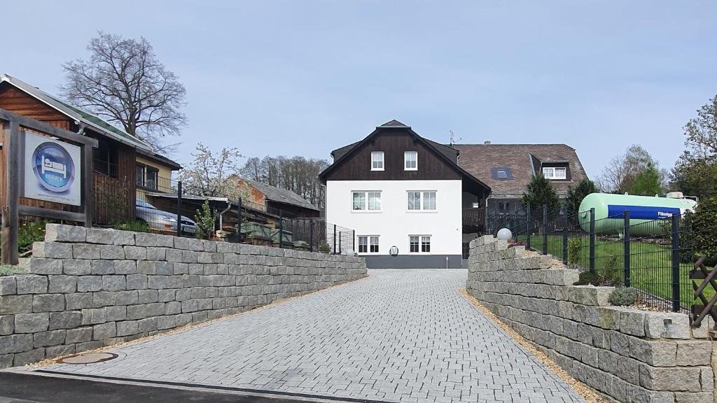 a cobblestone street in front of a white house at Apartment Marx in Taltitz