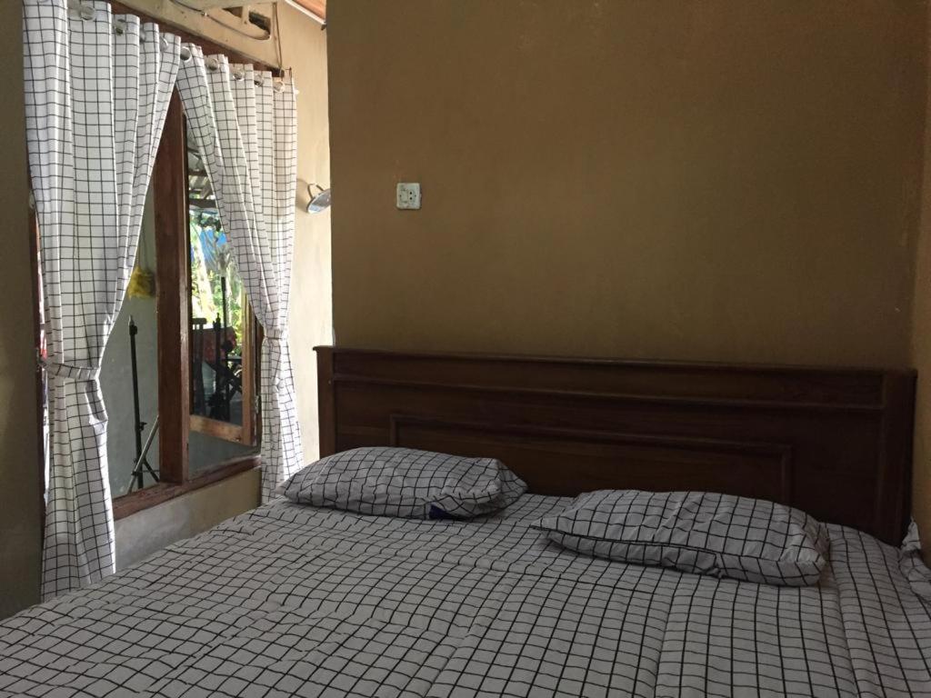 a bed with two pillows on it in a bedroom at De Ikut Bojo Homestay in Magelang