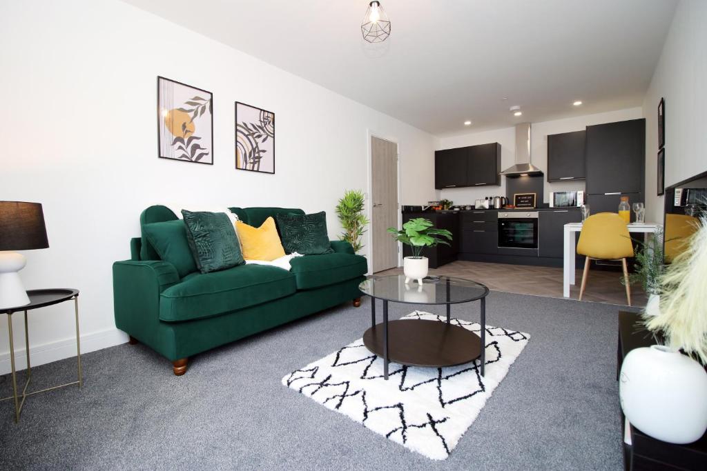 a living room with a green couch and a table at New Modern 1 Bedroom Apartments - Prime Location - By EKLIVING LUXE Short Lets & Serviced Accommodation - Cardiff in Cardiff