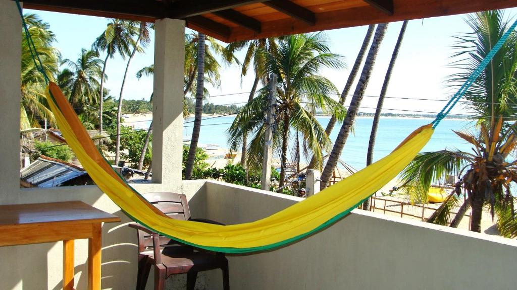 a hammock on a balcony with a view of the beach at Rupa's Hotel in Arugam Bay