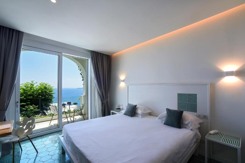 a bedroom with a large bed and a large window at Hotel Montemare in Positano
