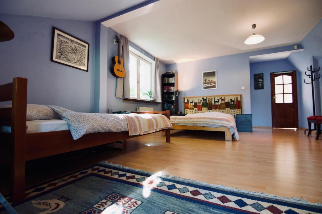 1 dormitorio con paredes azules y suelo de madera en Komfortowe przestronne pokoje z prywatnymi łazienkami blisko Warszawy i Suntago, en Milanówek
