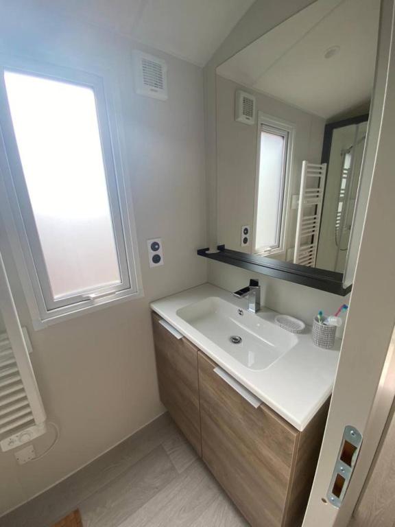 a white bathroom with a sink and a window at L&#39;arbre perché in Saint-Raphaël