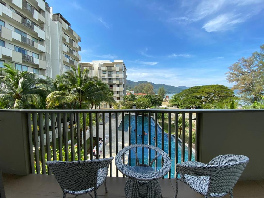 a balcony with chairs and a view of a pool at By The Sea@Side Seaview n swimming pool view #133A in Batu Ferringhi