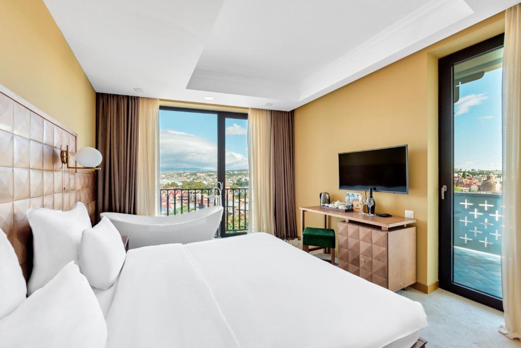 a hotel room with a bed and a television at Amante Narikala Boutique Hotel in Tbilisi City