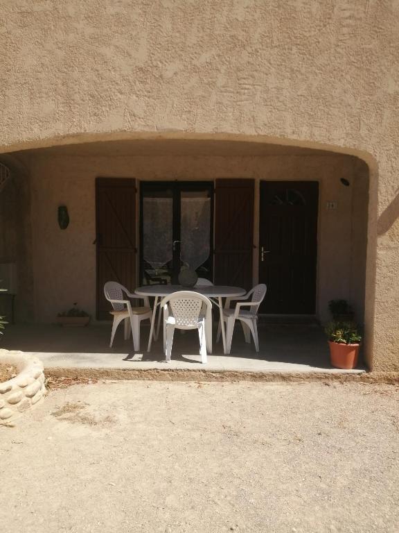 une table et des chaises assises sur une terrasse dans l'établissement Le Cigalou, à Sainte-Croix-de-Verdon