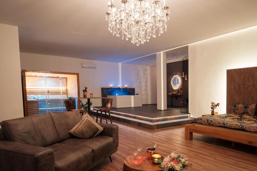 a living room with a couch and a chandelier at Privat-Spa mit Whirlpool und Sauna in Sursee in Sursee