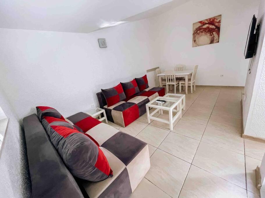 ein Wohnzimmer mit einem Sofa und einem Tisch in der Unterkunft Spacious One bedroom Apartment DIA in Budva