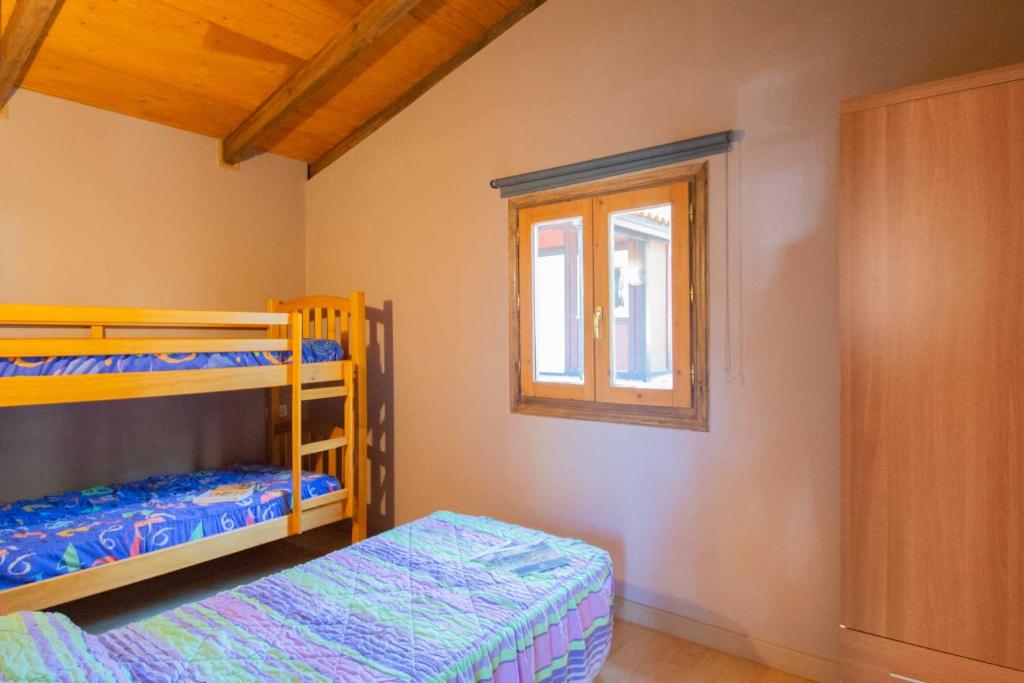 1 dormitorio con 2 literas y ventana en Camping Urbion, en Abejar