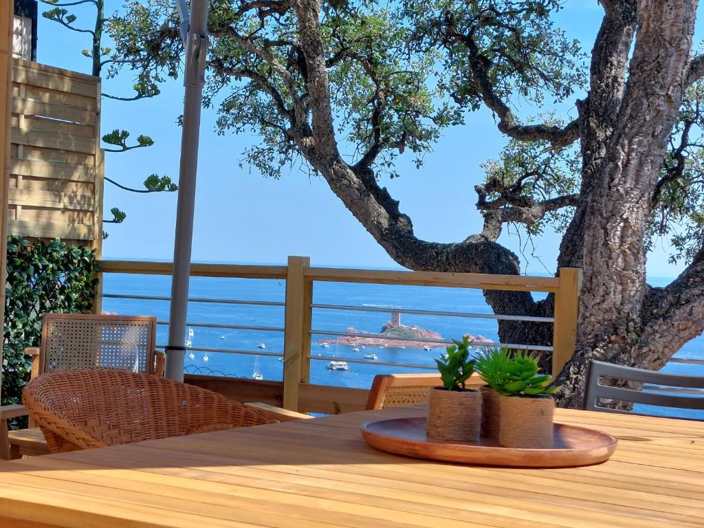 a table on a deck with a view of the ocean at L&#39;arbre perché in Saint-Raphaël