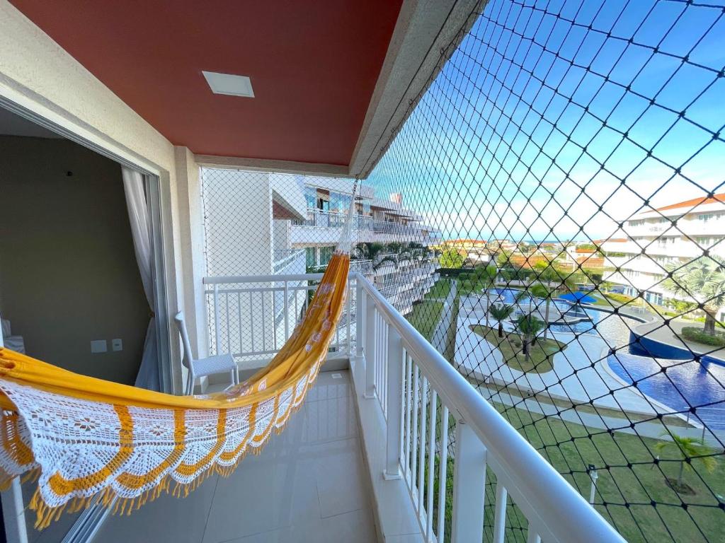 a balcony with a hammock on a cruise ship at Apartamento Confortável - Porto das Dunas - Perto do Beach Park in Aquiraz
