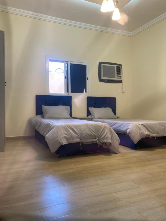 Habitación con 2 camas en una habitación con ventana en Al asalah apartments, en La Meca