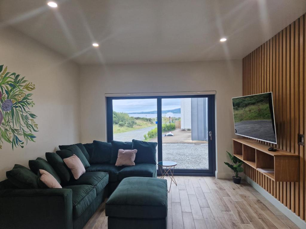 a living room with a couch and a sliding glass door at Sea View Studio in Buncrana