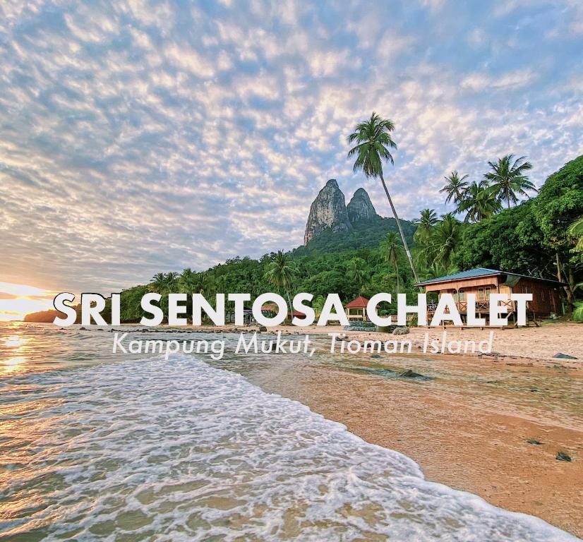 - une vue sur une plage avec une montagne en arrière-plan dans l'établissement Sri Sentosa Chalet, à l'Île Tioman