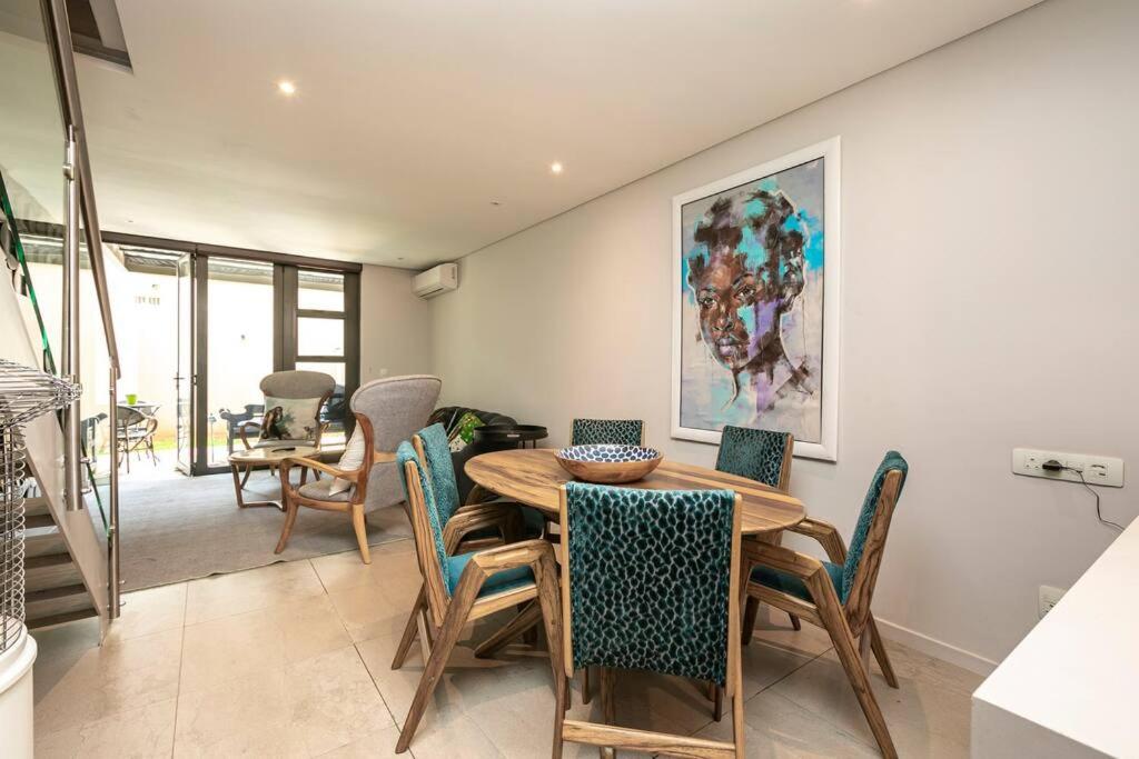 a dining room with a wooden table and chairs at Stylish Apartment w/ inverter 1km 2Hyde Park in Johannesburg