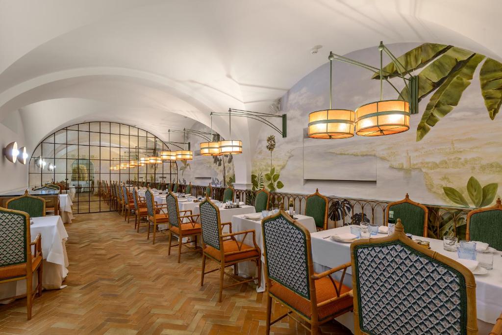een rij tafels en stoelen in een restaurant bij CoolRooms Palacio Villapanés 5 GL in Sevilla