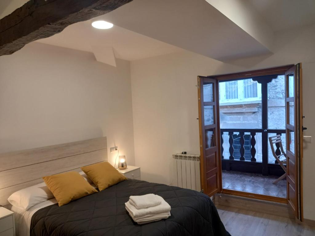 a bedroom with a bed with two towels on it at Hotel Rural Virgen del Carmen in Molinaseca