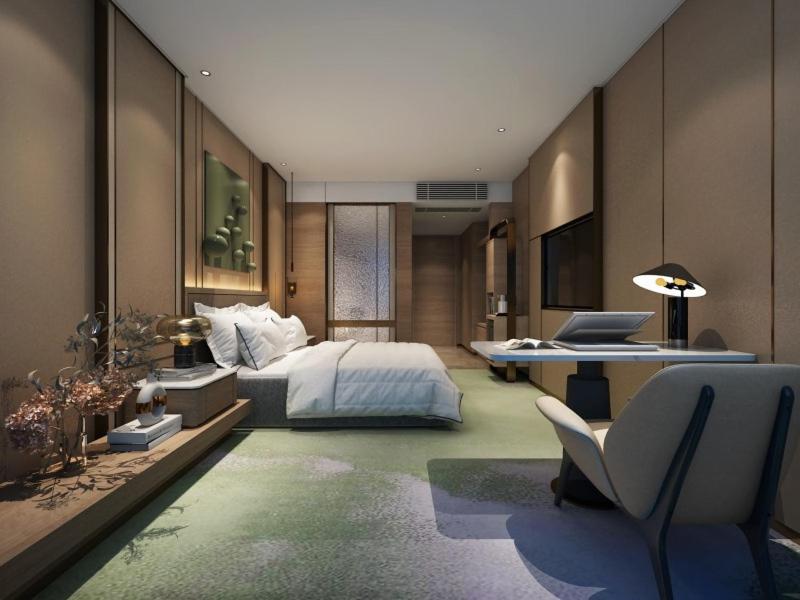 Geli Hotel Bengbu Wanda Plaza Nanxiang City في Bengbu: غرفة نوم بسرير ومكتب وكرسي