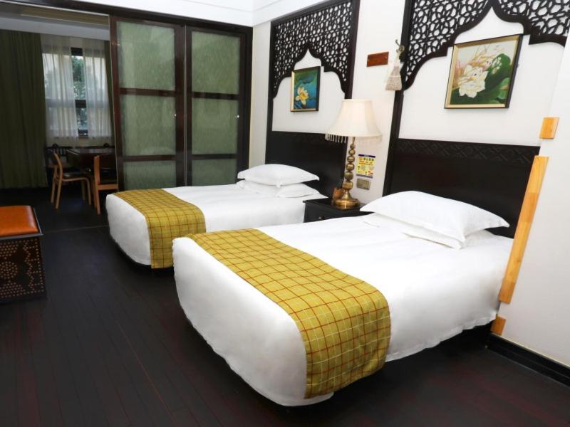 a hotel room with two beds and a table at GreenTree Eastern Hotel Yueqing Shifu Chenmu Square in Yueqing