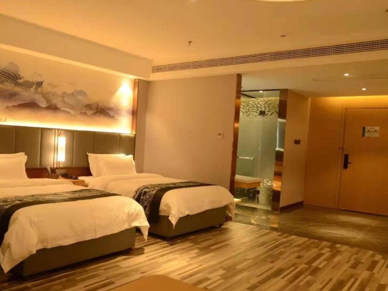 a hotel room with two beds and a bathroom at GreenTree Eastern Hotel Dezhou Qingyun Yingcai Road Financial Building in Dezhou