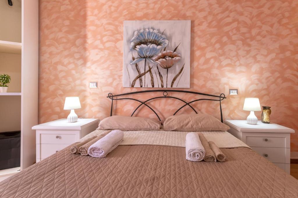 1 dormitorio con 1 cama con 2 lámparas y 1 pintura en Relax House and Fitness 8 en Villanova Monteleone