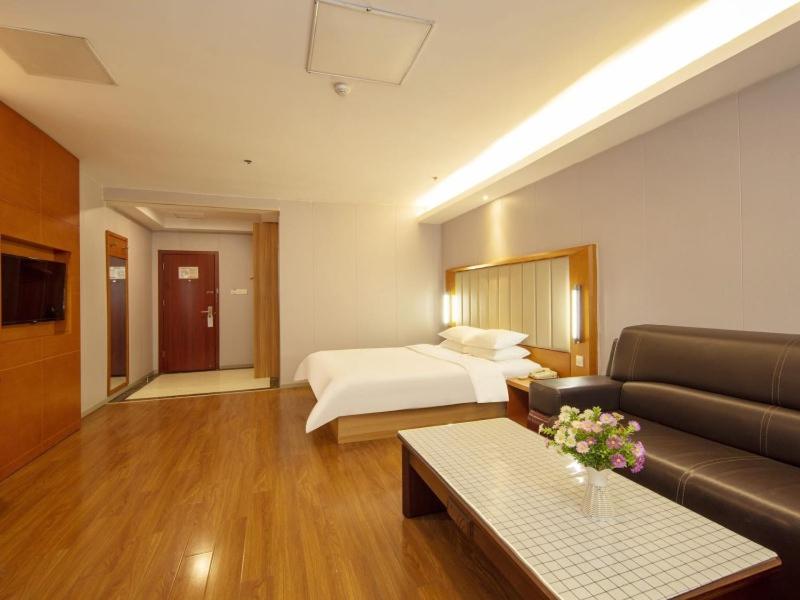 a hotel room with a bed and a couch at Deep Sleep Hotel Hangzhou Dajiang East Haide Xingang Center in Hangzhou