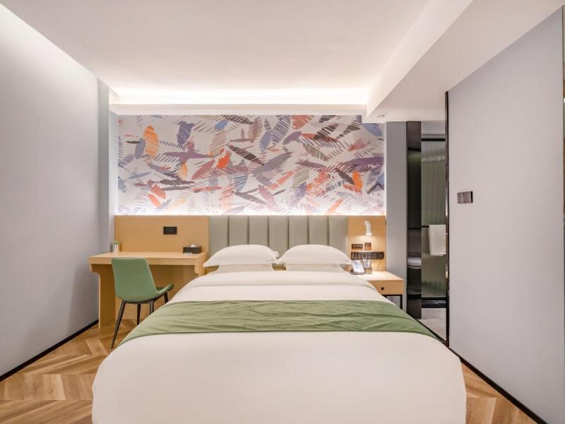 een slaapkamer met een groot wit bed en een bureau bij GreenTree Inn Express Hotel Changzhou Wujin Economic Development Zone Qishuyan Yaoguan in Changzhou