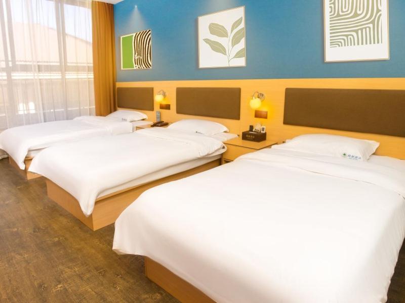 una habitación de hotel con 3 camas en una habitación en Geli Hotel Hefei Modian University Mengxi Town, en Hefei