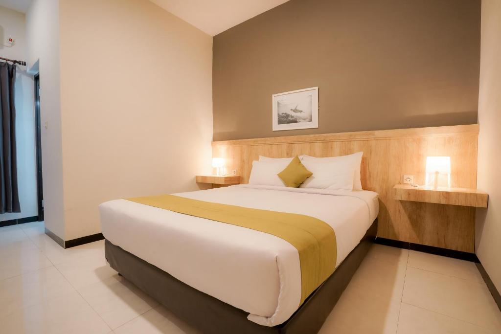 ラブハン・バジョにあるEl Ora Hotel & Eatery Labuan Bajoのベッドルーム1室(大型ベッド1台、ナイトスタンド2台付)