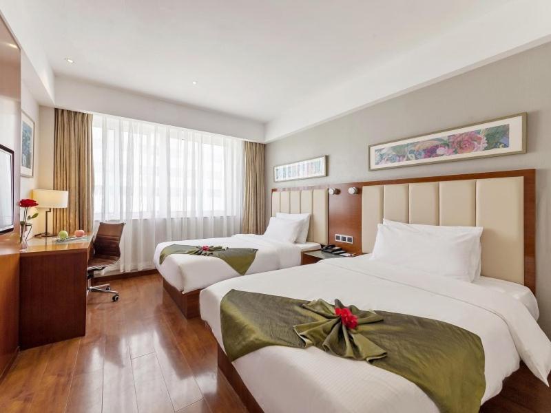Postel nebo postele na pokoji v ubytování GreenTree Eastern Hotel Fujian Xiamen Railway Station Mingfa Plaza