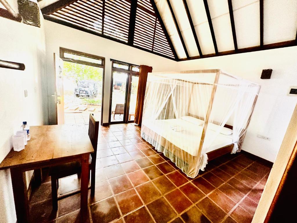 a bedroom with a bed with a mosquito net at Riva del Sole Guest House in Arugam Bay
