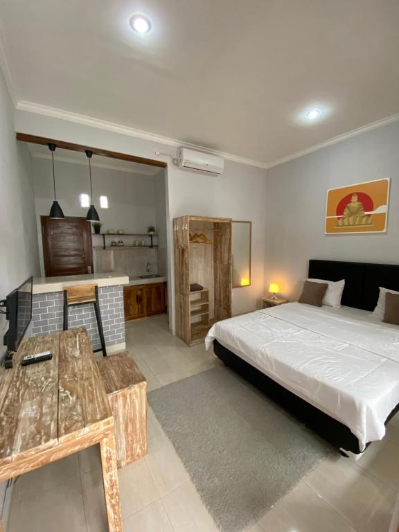 ein Schlafzimmer mit einem Bett und einem Schreibtisch. in der Unterkunft LaGriya Guest House in Ketewel