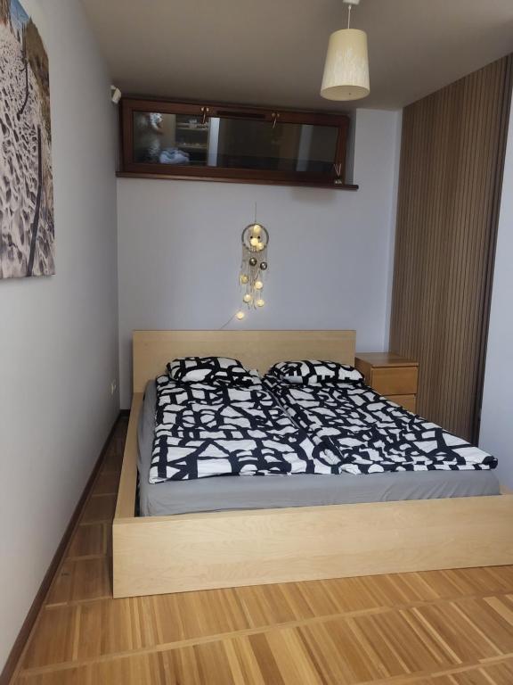 a bedroom with a bed with a black and white comforter at Apartament HEL in Hel