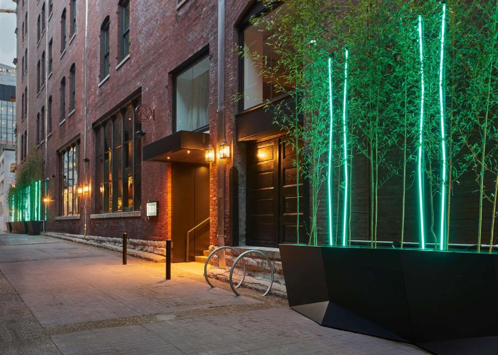 a building with a tree in a planter on a street at The Bankers Alley Hotel Nashville, Tapestry Collection by Hilton in Nashville